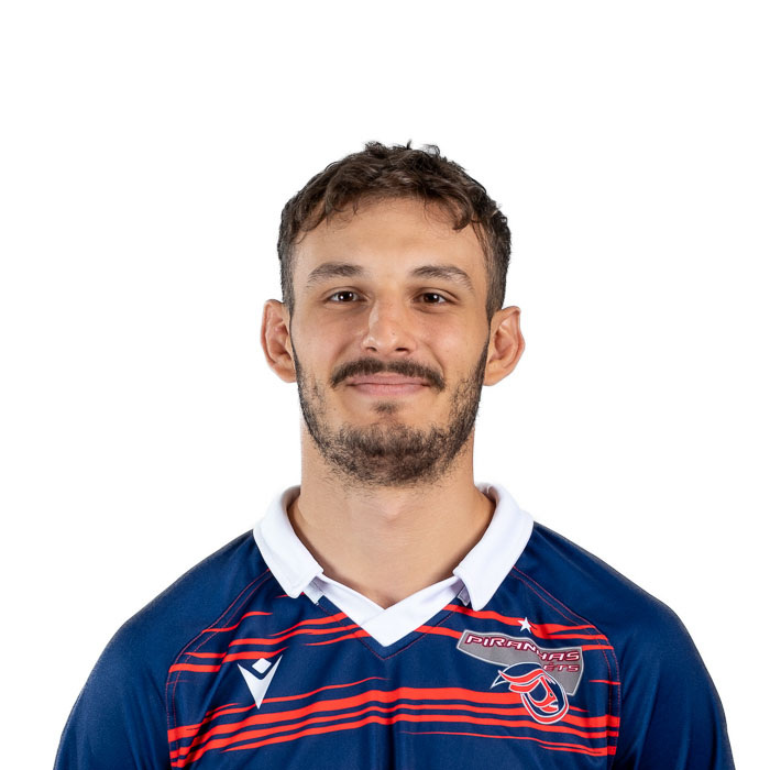 Étudiant sportif en tenue de rugby, souriant légèrement, fond blanc.