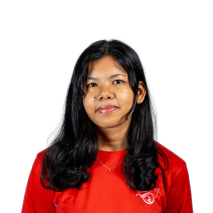 Étudiante souriante en t-shirt rouge, prête à relever des défis en technologie. Ambition et détermination se dégagent de son regard.