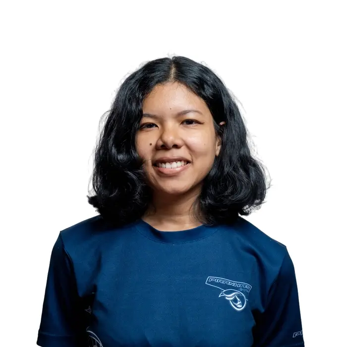 Étudiante souriante en t-shirt rouge, prête à relever des défis en technologie. Ambition et détermination se dégagent de son regard.