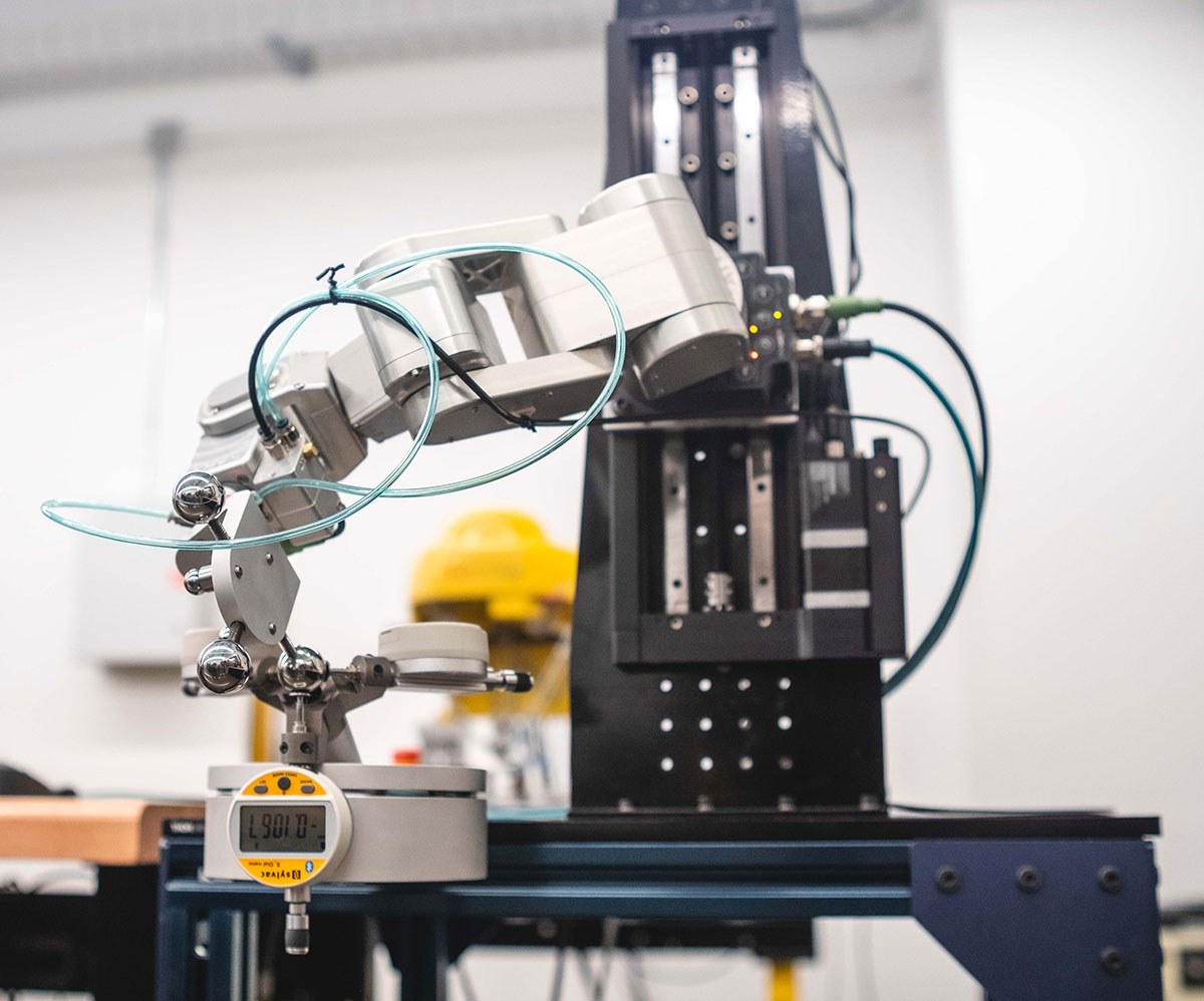 A robotic arm equipped with sensors for precision tasks in a technology lab setting.