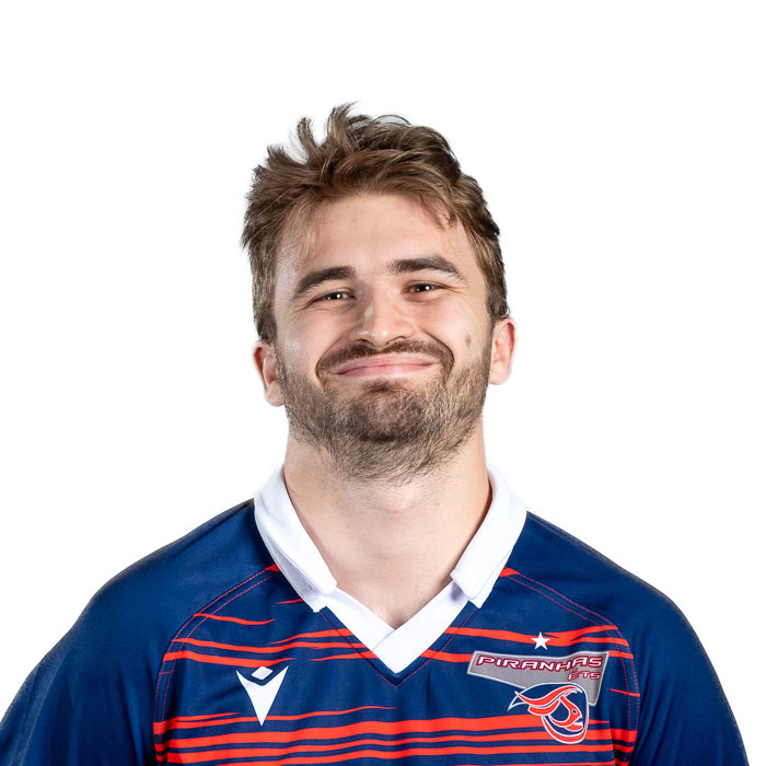 Jeune homme souriant en maillot de rugby, ambiance sportive et dynamique. Énergie positive et esprit d'équipe.