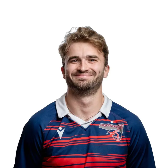 Jeune homme souriant en maillot de rugby, ambiance sportive et dynamique. Énergie positive et esprit d'équipe.