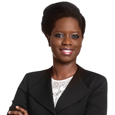 Professionnelle souriante et confiante, vêtue d'un costume noir, avec des cheveux coiffés, mettant en avant une allure dynamique et inspirante.