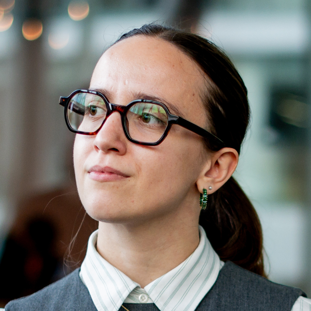 A thoughtful individual in glasses displays a professional demeanor, embodying a blend of style and intellect.