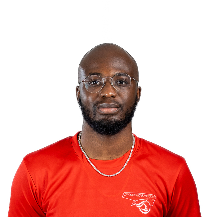 Étudiant en technologie, maillot sportif bleu et blanc, lunettes, sérieux.