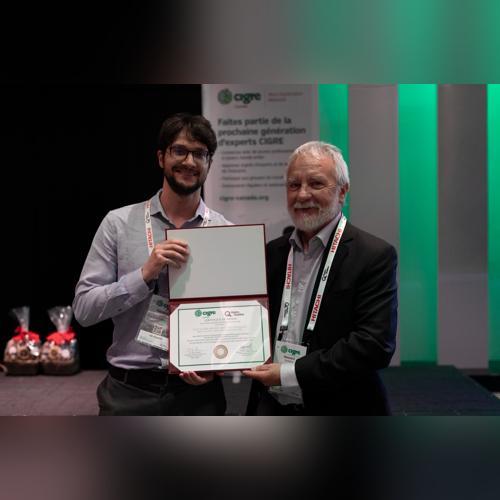 Award presentation to a student, celebrating academic excellence with a mentor at a prestigious event.