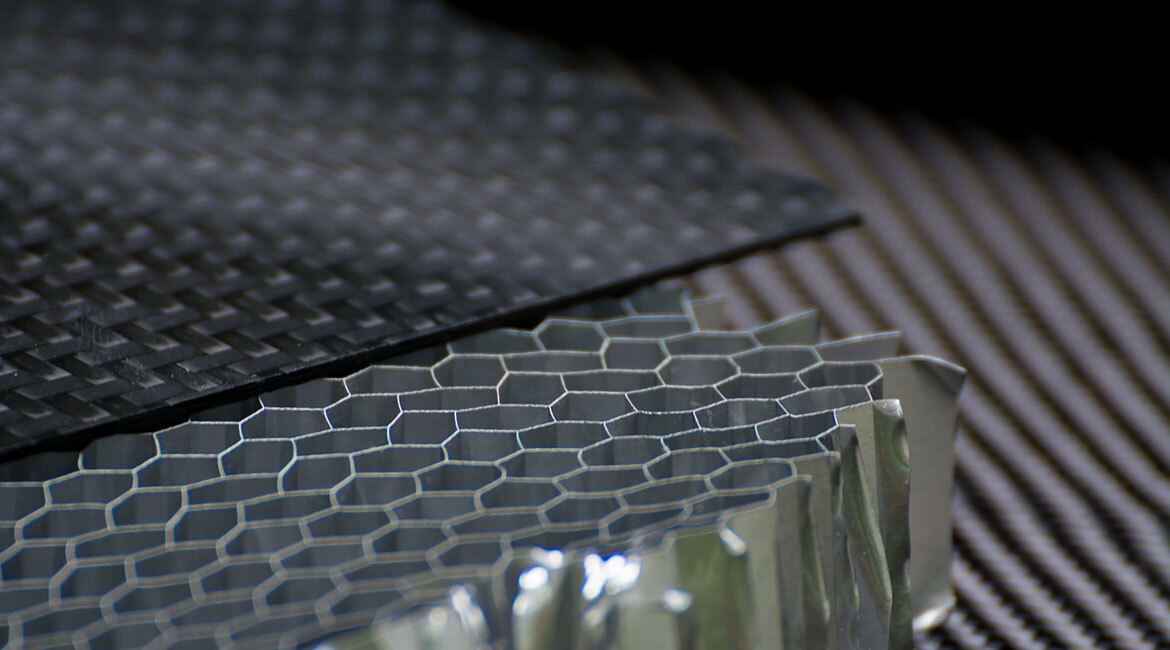 Advanced materials showcase, featuring a textured black composite and honeycomb structure, highlighting innovation in technology.