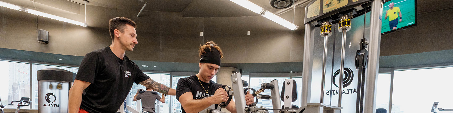 Entraînement en salle avec un coach personnel, utilisant des équipements modernes dans un environnement stimulant et motivant.