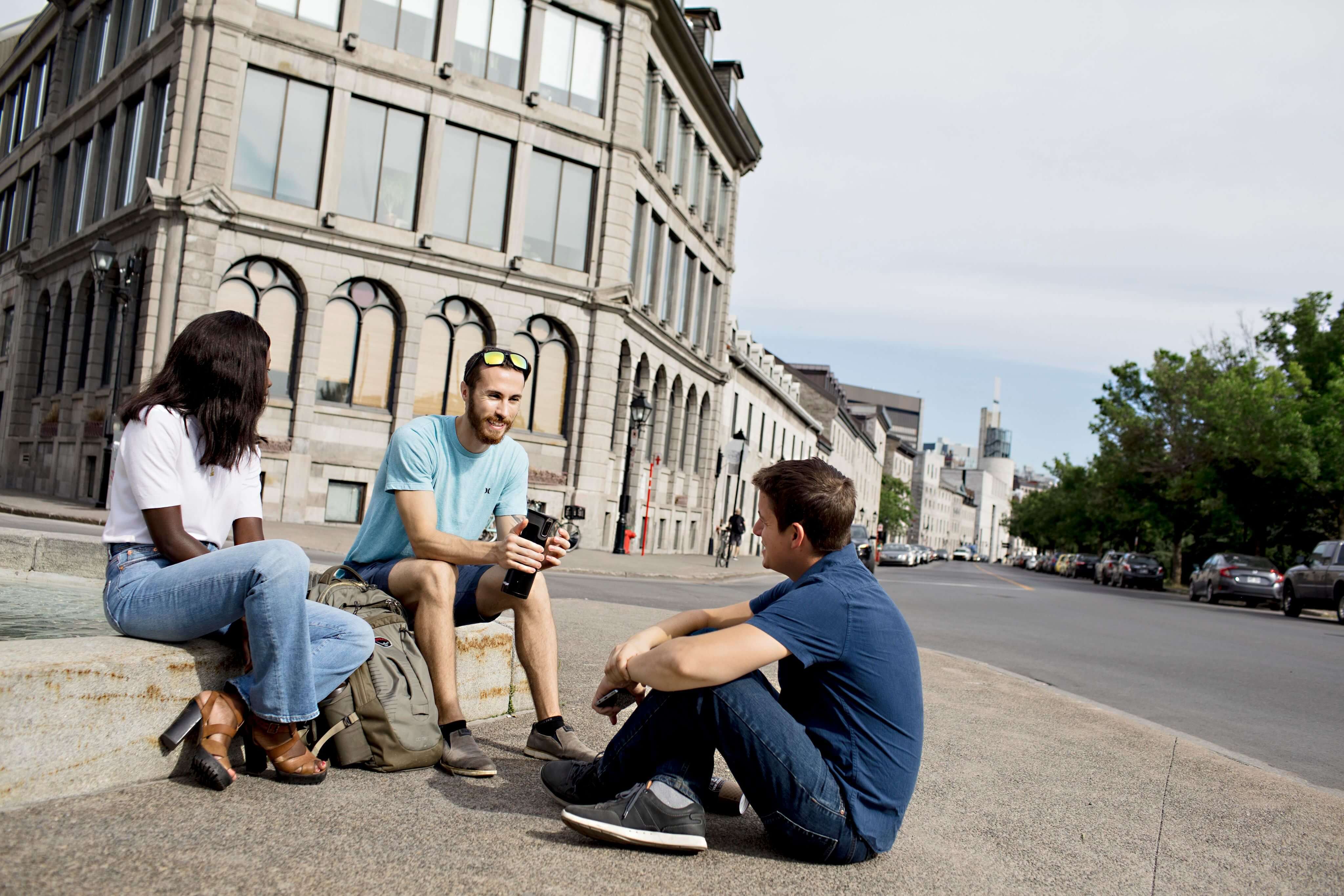 Étudiants détendus discutant près du campus.