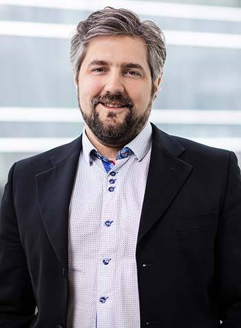 Professional in suit with a confident smile at a tech university.