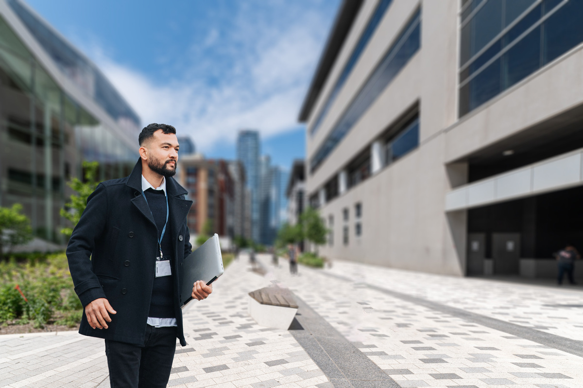 Étudiant en technologie avance avec assurance sur le campus.