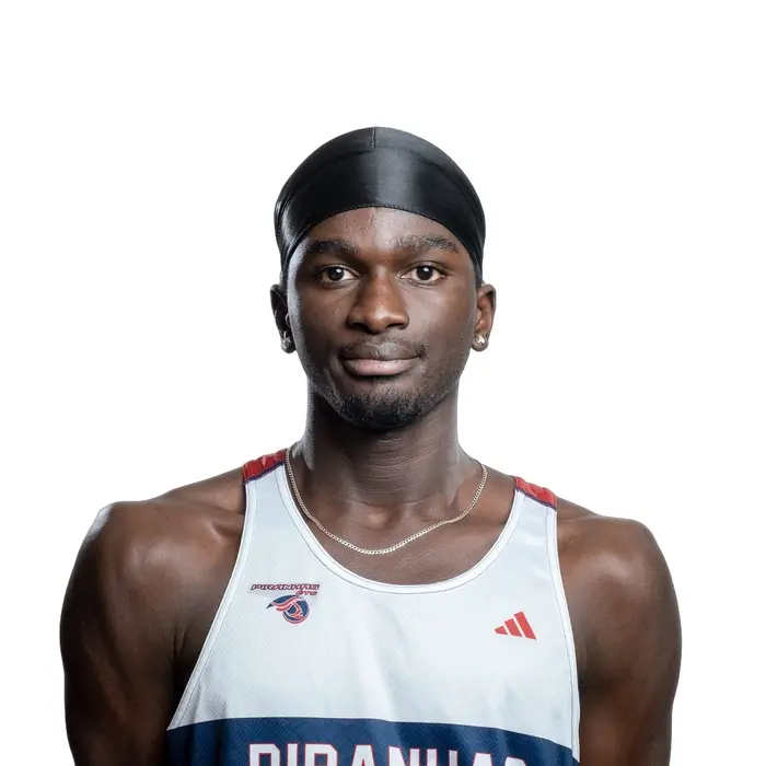 Athlète déterminé portant un maillot d'équipe, affichant confiance et concentration dans un cadre sobre.