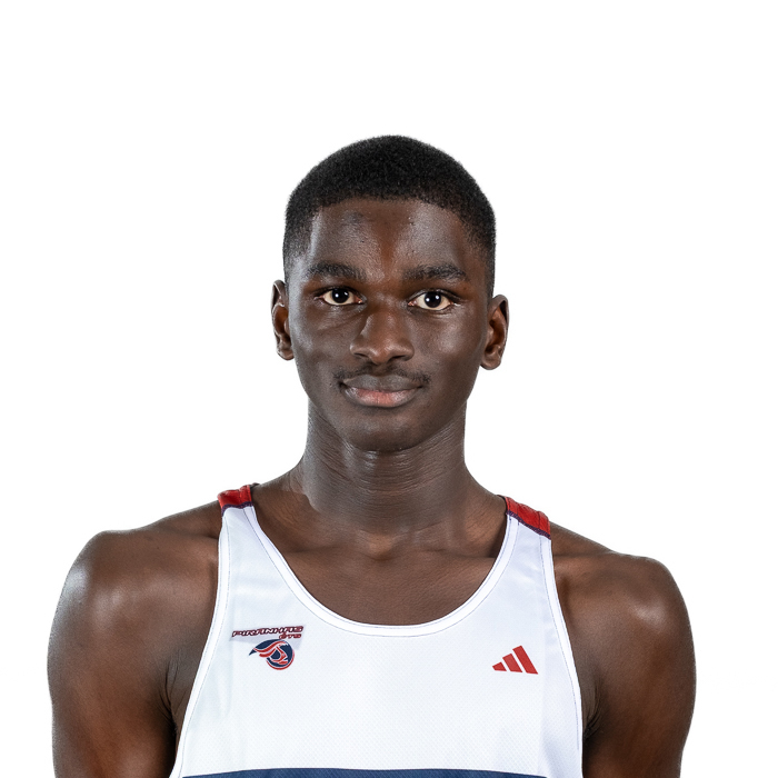 Athlète déterminé portant un maillot d'équipe, affichant confiance et concentration dans un cadre sobre.