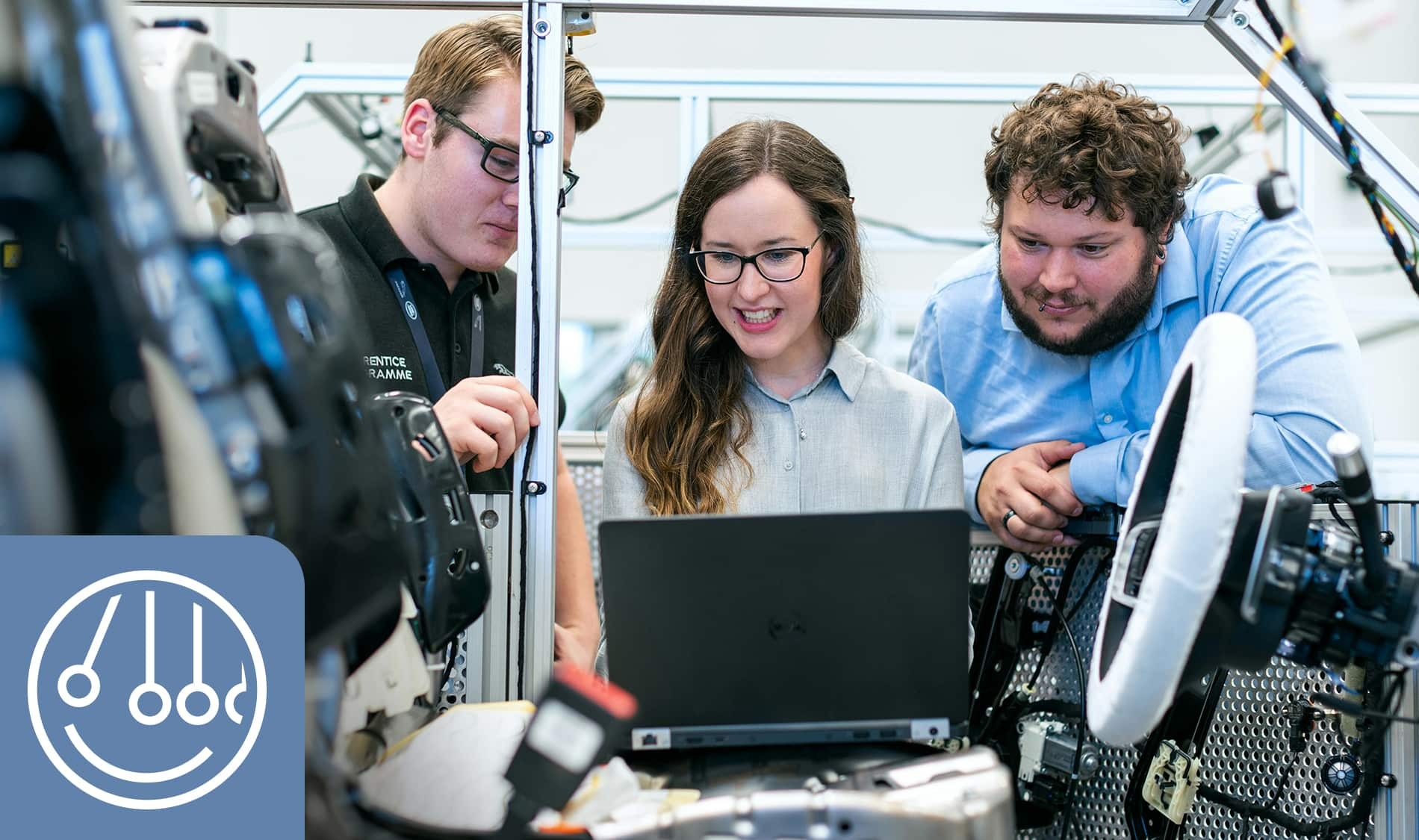 Des étudiants collaborent sur un projet technologique, explorant des solutions innovantes autour d'un ordinateur et d'équipements mécaniques.