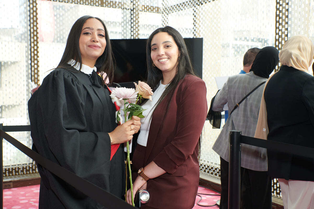 Cérémonie de remise de diplômes avec étudiantes heureuses.