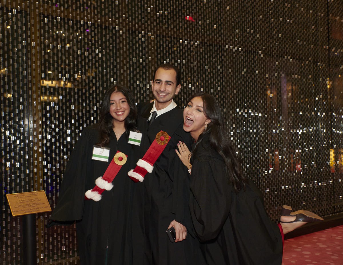 Célébration joyeuse de diplômés en toge, sourires et amitié, sous une ambiance festive et lumineuse. Un moment mémorable partagé.