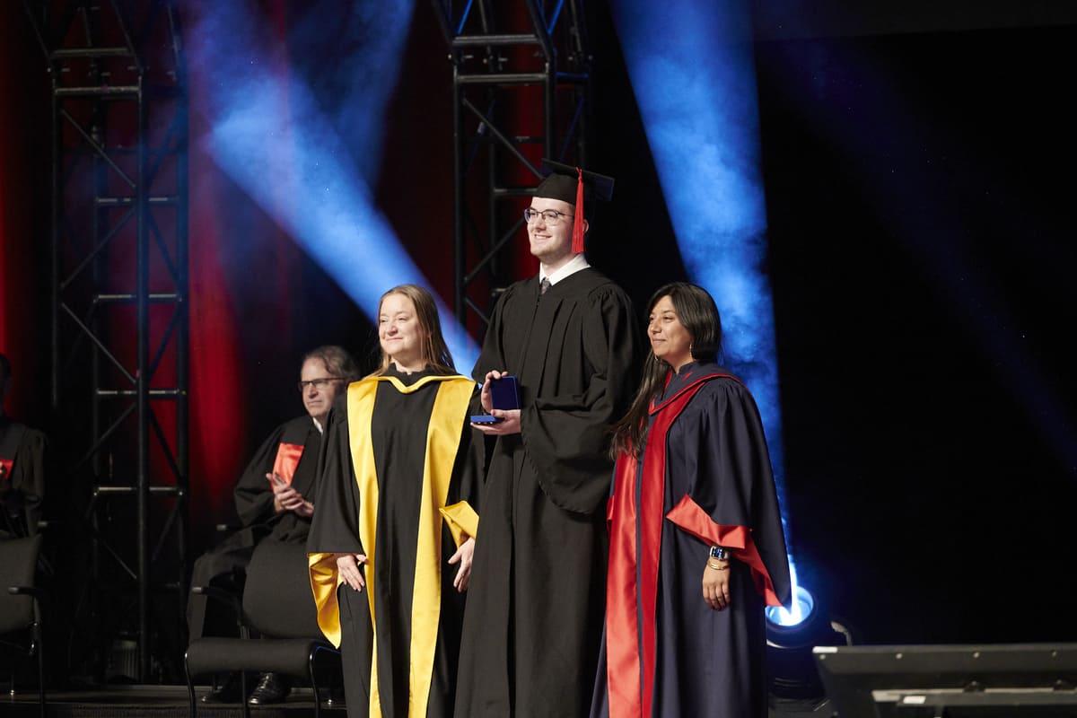 Cérémonie de remise de prix avec des gradués fiers, sous un éclairage festif, illustrant l'accomplissement académique.
