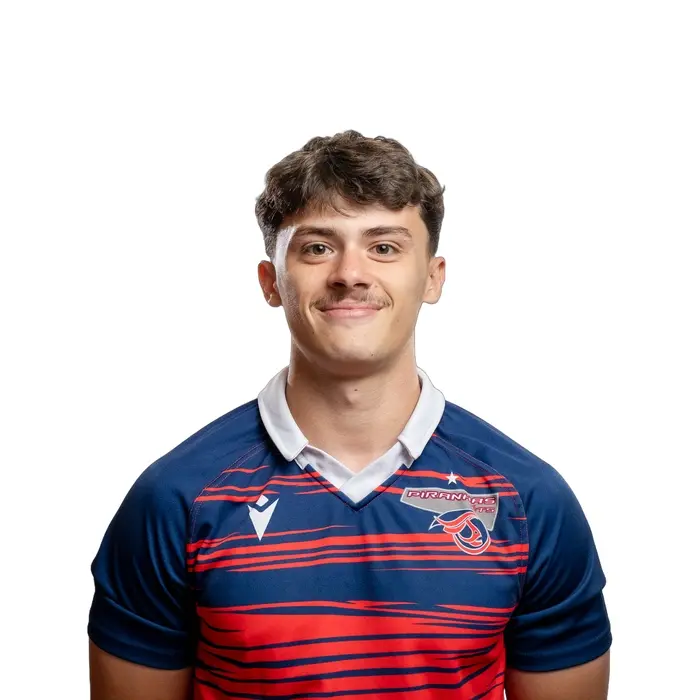 Étudiant en technologie, portant un maillot de l'équipe des Piranhas, affichant un sourire confiant et déterminé.