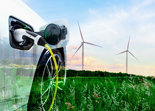 Chargement de voiture électrique avec éoliennes en fond, symbolisant l'énergie renouvelable et la technologie propre.