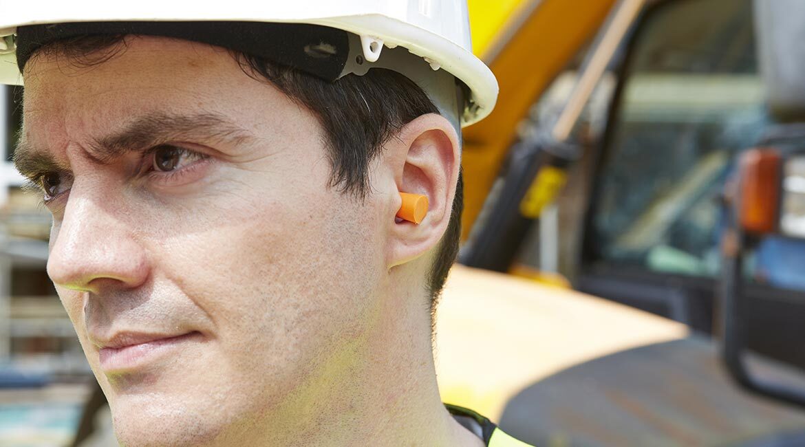 Ingénieur en casque avec bouchons d'oreilles sur un chantier.