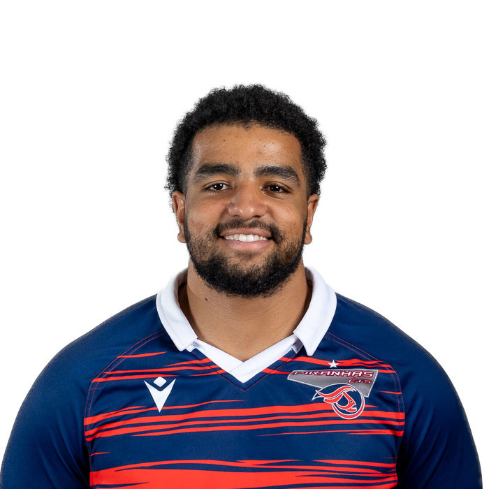 Étudiant en technologie supérieure, il affiche une large sourire, portant un maillot aux couleurs de l’équipe universitaire de rugby.