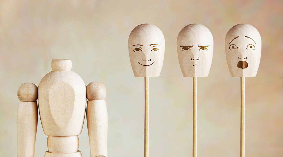 Figurines en bois illustrant diverses émotions, symbolisant l'intelligence émotionnelle.