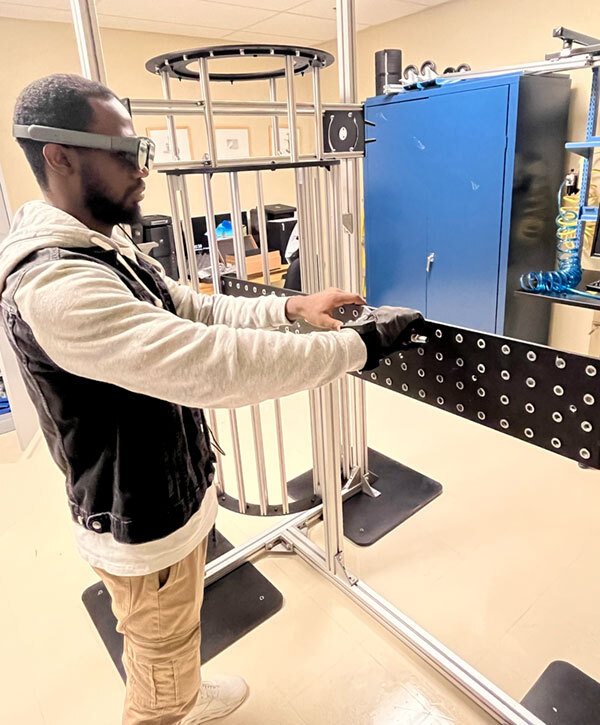 A student uses advanced technology and equipment in a lab setting, focusing on practical applications in higher education.