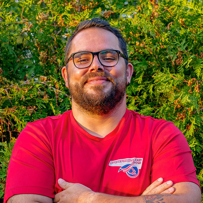 Étudiant en sweat à capuche de l'équipe sportive, souriant, extérieur.