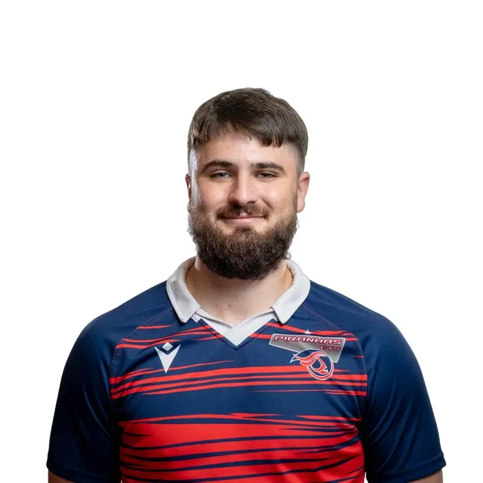 Étudiant souriant en polo d'équipe de rugby, représentant l'esprit d'équipe et la détermination au sein de l'Université.