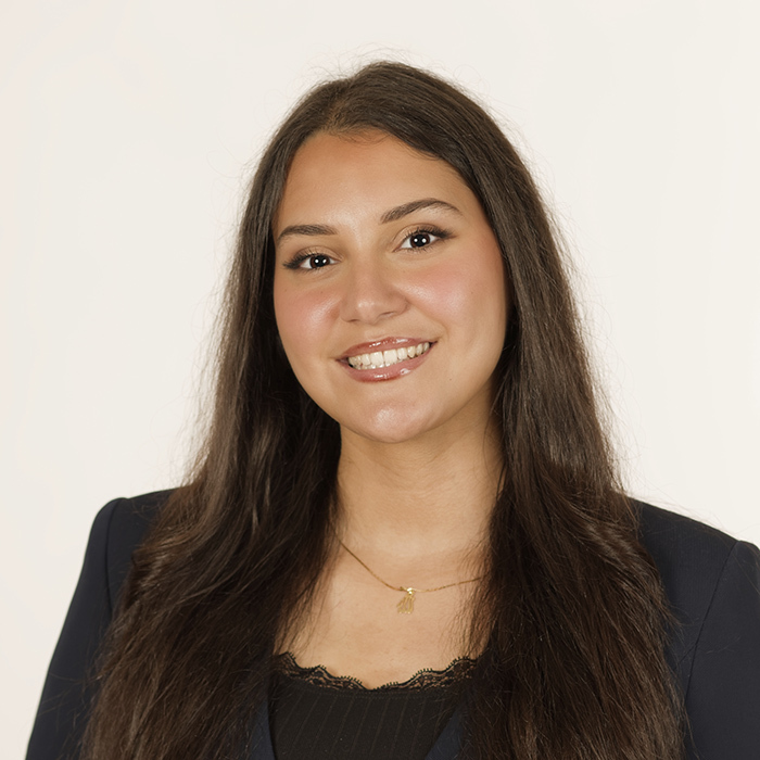Portrait d'une étudiante souriante, portant un blazer, mettant en avant sa détermination et son professionnalisme. Élan vers l'avenir.
