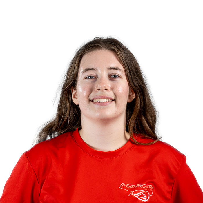 Étudiante souriante portant un maillot rouge, représentant l'esprit engagé et dynamique de l'Université en technologie supérieure.