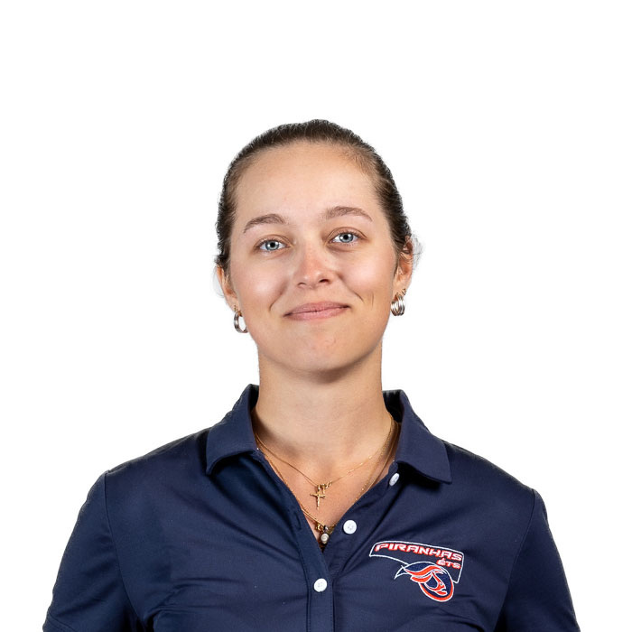 Personne souriante avec lunettes, polo bleu à logo "Piranhas".