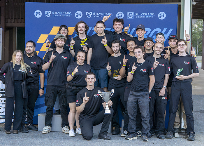 Équipe soudée célébrant une victoire, fiers de leur trophée et des performances réalisées lors d'une compétition.