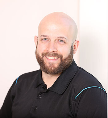 Confident professional with a friendly demeanor, possibly a faculty or staff member at a tech university.