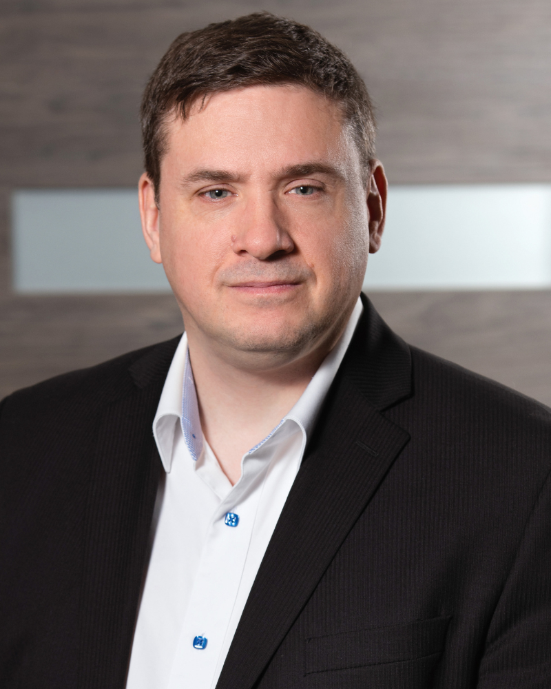 Homme en costume avec badge d'identité, sérieux et professionnel.