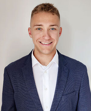 Étudiant dynamique en technologie, souriant et vêtu professionnellement, prêt à relever de nouveaux défis dans son domaine.