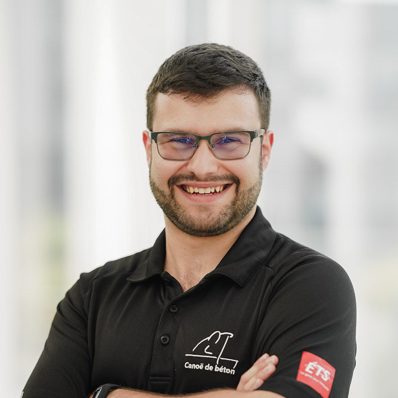 Étudiant souriant en polo noir, il incarne l'esprit de l'innovation à l'Université en technologie supérieur. Passionné et dynamique.