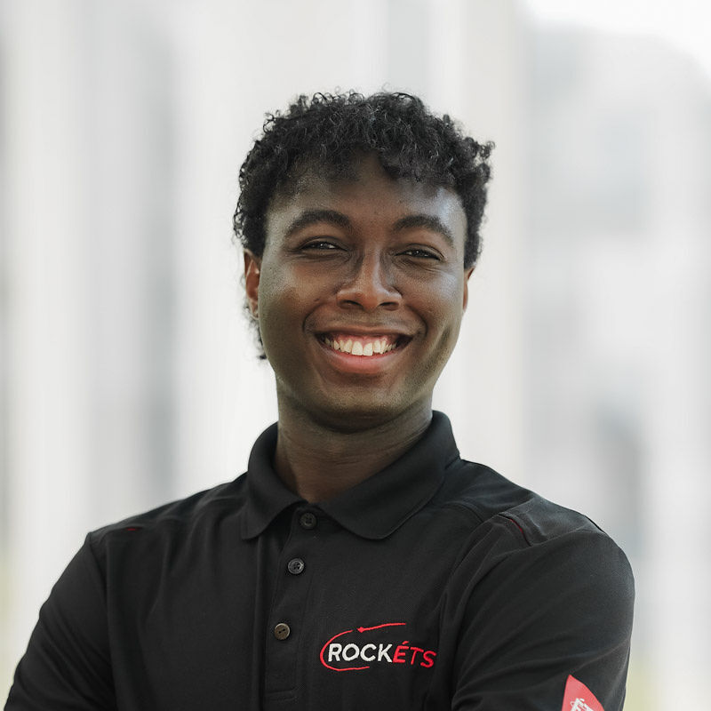 Un étudiant souriant en polo noir portant le logo "ROCKETS", mettant en avant l'esprit d'innovation et de camaraderie.