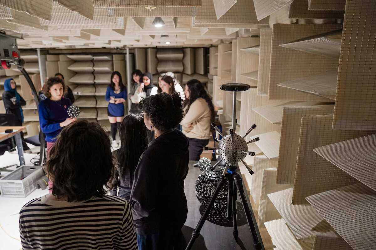Un groupe d'étudiants assiste à une présentation sur les technologies acoustiques dans un environnement spécialisé.