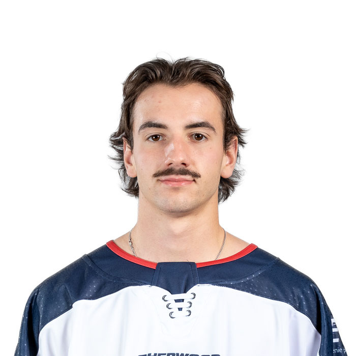 Étudiant souriant en maillot bleu avec logo ETS, exprimant l'esprit sportif de l'école.
