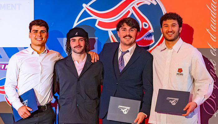 Célébration de diplômés en ingénierie, avec quatre étudiants posant fièrement avec leurs diplômes. Ambiance festive et amicale.