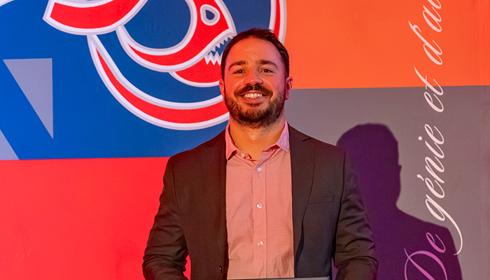Célébration d'un diplômé, accompagné d'un sourire, devant des arrières-plans dynamiques aux couleurs de l'université.