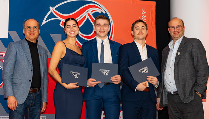 Célébration de diplômés, mettant en avant des étudiants en tenue formelle et un professeur, symbolisant la réussite académique.