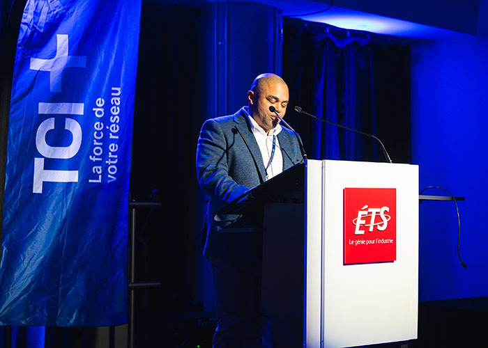 Un intervenant prend la parole lors d'un événement à l'Université de Technologie Supérieure, mettant en avant l'innovation et le réseau.