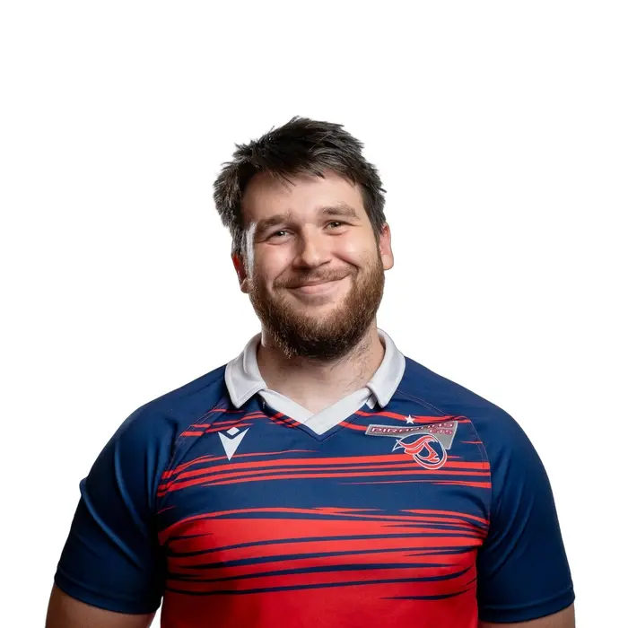 Étudiant souriant en maillot sportif, évoquant dynamisme et esprit d'équipe universitaire.
