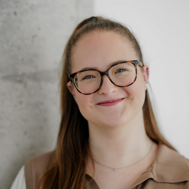 Étudiante souriante en environnement moderne, mettant en avant sa confiance et sa passion pour la technologie.