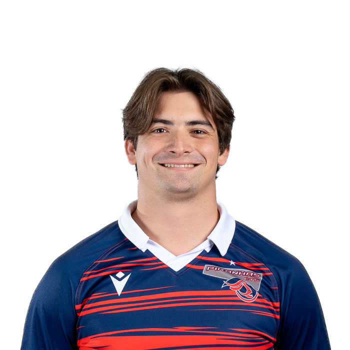 Étudiant souriant portant un maillot sportif aux couleurs vives, représentant fièrement son équipe universitaire.