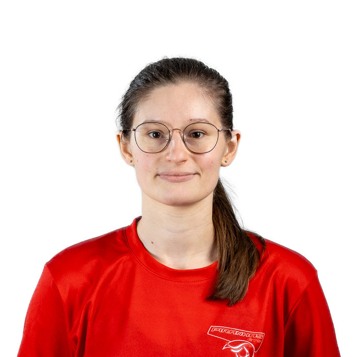 Étudiante avec lunettes, souriante, portant un maillot bleu sportif.