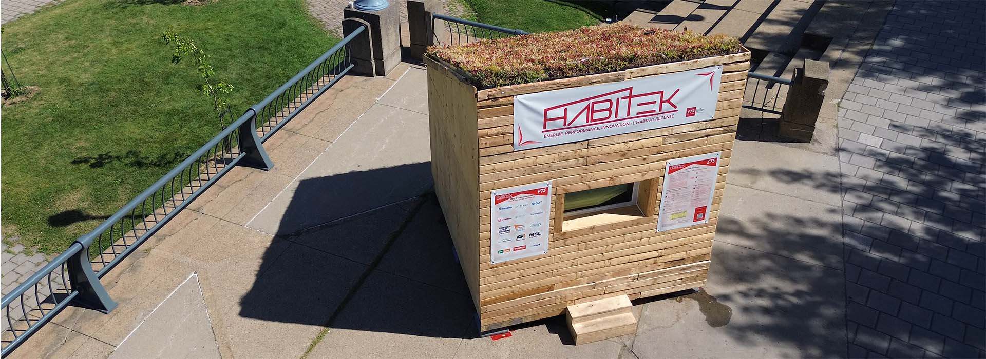 Habitat innovant en bois avec un toit végétal, illustrant l'engagement pour l'énergie et la performance durable.