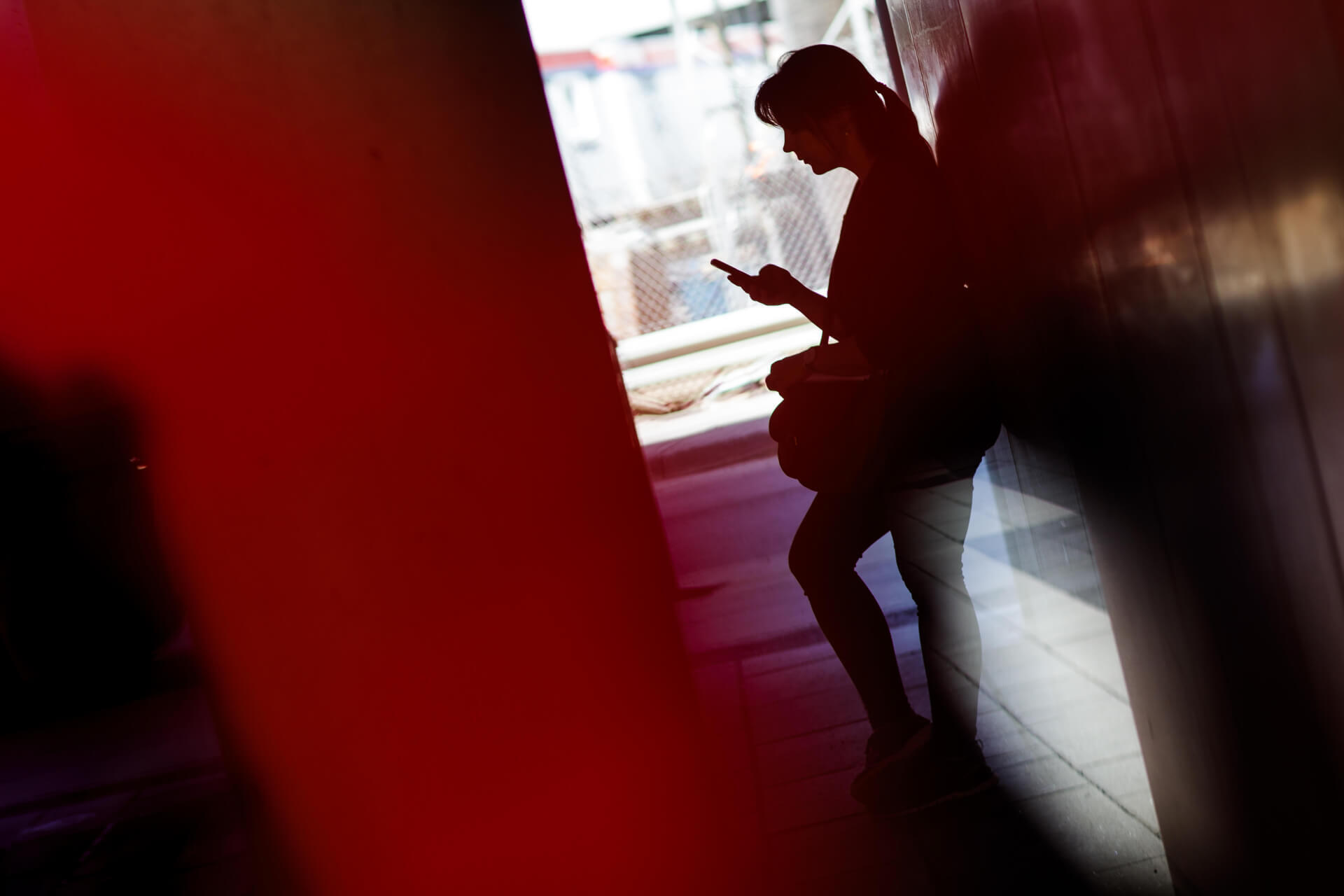 Étudiant utilisant son smartphone, contraste de lumière et d'ombre, ambiance moderne.